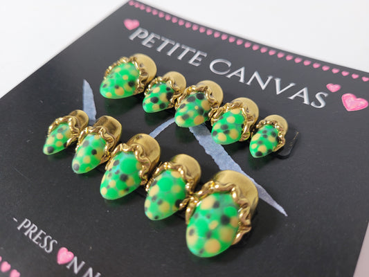 Close-up of Gold and Scales small almond press-on nails — green with molten gold scale details