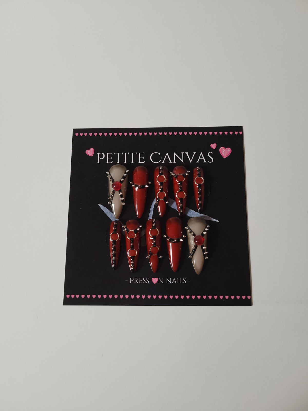Full set of REBIRTH handmade press-on nails, long stiletto, red and nude with metal details