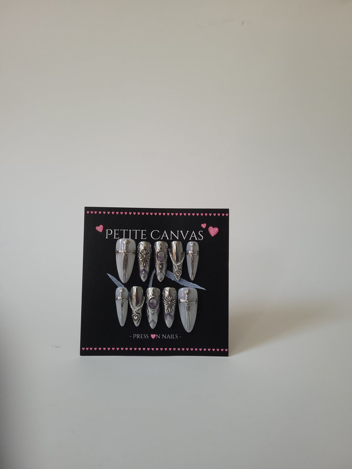 Snow Queen full press-on nail set on display card — silver chrome armor with sword and filigree details, long almond